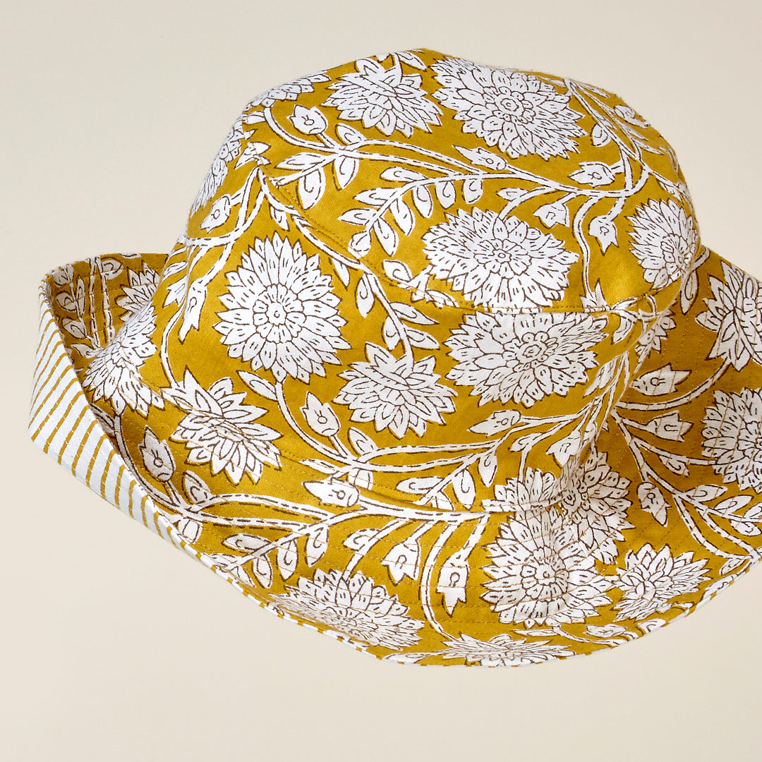 Gorro Rimini flores y rayas de algodón en color turquesa y mostaza reversible